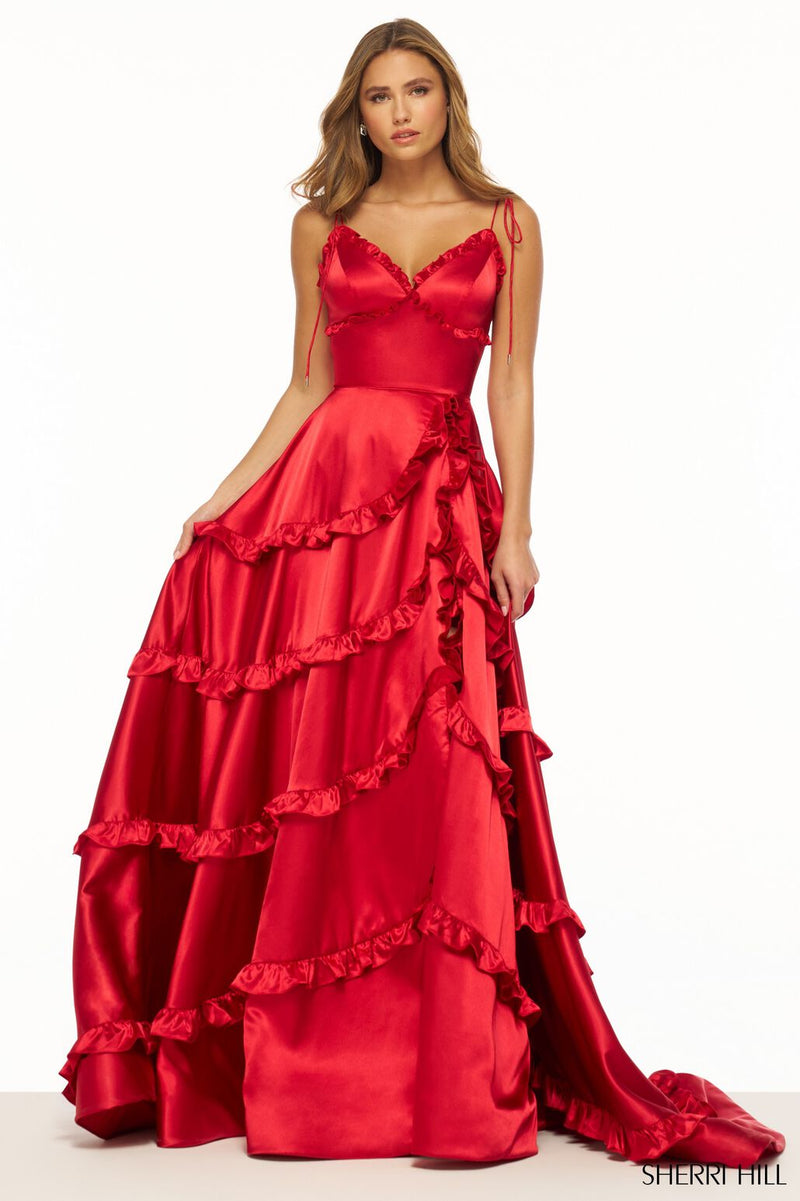 This dress features satin fabric with ruffle embellishments throughout the bodice and skirt. This gown has a v-neckline with spaghetti straps that tie at the top. It is feminine and vibrant and could be styled to make it your own at your next prom or formal event.  Sherri Hill 56353
