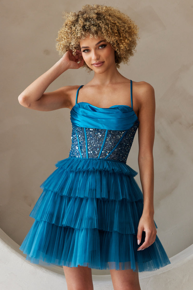 This dress features an intricate bodice with pleating, corset boning and sequin fabric, a tiered tulle skirt creating an A-line silhouette. This dress is playful and could be ideal for your next homecoming, sweethearts or formal event.  ACE BZ9023S