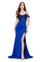 This dress features a sequin and bead embellished bodice, with a sweetheart neckline, a cold-shoulder design with spaghetti straps and off-the-shoulder straps. This gown has a fitted silhouette, a side slit, jersey fabric and a slight train. An elegant choice for your next prom or formal event.  Ashley Lauren 11391