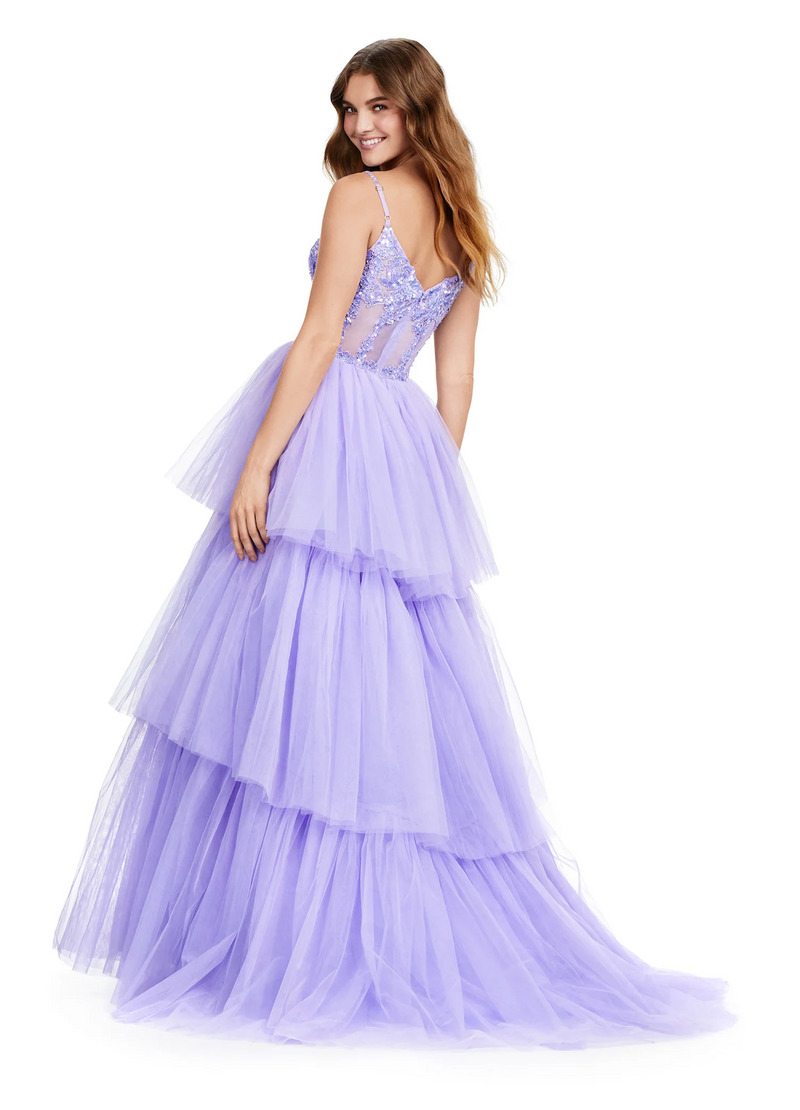 This tiered tulle ball gown features a sheer beaded bustier complete with spaghetti straps and an illusion plunge neckline. The tiered ruffle skirt completes this modern look. Choose this stunning gown for your next prom or formal event.   Ashley Lauren 11462