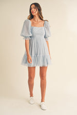 This dress features pearl stud swiss dot mesh with a short puff ruffle sleeve a babydoll silhouette with an open-back self-tie detail. This playful dress is an excellent choice for your next homecoming, sweethearts dance or formal event!  MAE-MD4369
