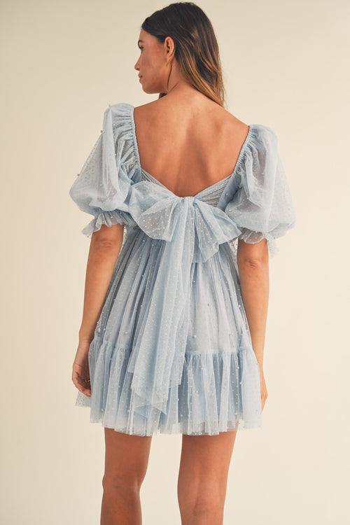 This dress features pearl stud swiss dot mesh with a short puff ruffle sleeve a babydoll silhouette with an open-back self-tie detail. This playful dress is an excellent choice for your next homecoming, sweethearts dance or formal event!  MAE-MD4369