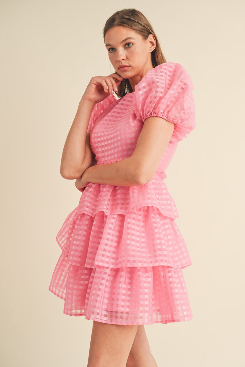 This modest cocktail dress features puff sleeves, plaid organza jacquard fabric, a round neckline and a ruffle waist with a tiered layered skirt. Style this dress to make it your own at your next homecoming or formal event!  MCI MDR2968
