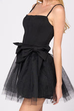 This cocktail dress features a straight across neckline with adjustable spaghetti straps, with 2 dramatic bows on the hips and a tulle skirt. This dress is playful and unique and could be just the vibe for your next homecoming or formal event.&nbsp;  PVY PD77204