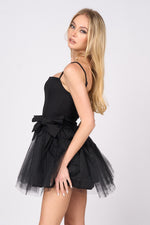 This cocktail dress features a straight across neckline with adjustable spaghetti straps, with 2 dramatic bows on the hips and a tulle skirt. This dress is playful and unique and could be just the vibe for your next homecoming or formal event.&nbsp;  PVY PD77204