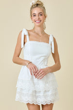 This cocktail dress features a straight across neckline with straps with ties at the shoulder, double tiered layered skirt with lace trim. This dress could be just the vibe for your next homecoming or formal event.

DM A3412