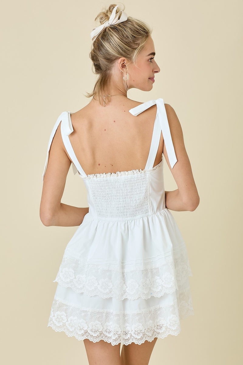 This cocktail dress features a straight across neckline with straps with ties at the shoulder, double tiered layered skirt with lace trim. This dress could be just the vibe for your next homecoming or formal event.

DM A3412