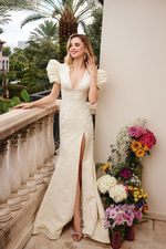 This dress features a soft blush tone with intricate lace detailing. The dress showcases a deep V-neckline and short puff sleeves, adding a romantic touch to the design. The fitted silhouette accentuates the body’s curves, while the high slit in the skirt adds a bold and modern element. The lace overlay provides a delicate texture, making it ideal for any formal event, prom or pageant.

ARY 40100