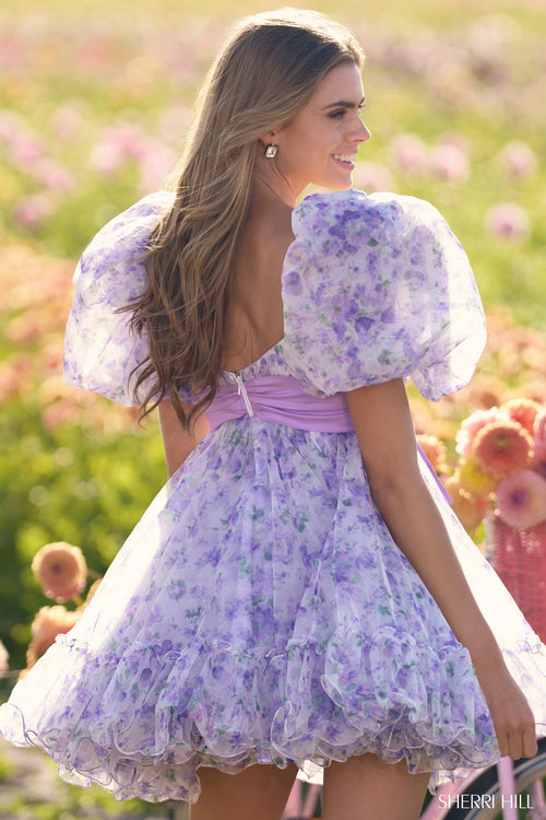 This cocktail dress features organza floral print fabric, with a baby doll silhouette with ruffle embellishments, a taffeta bow and balloon sleeves. This is a fun and playful choice for your next homecoming or formal event.

Sherri Hill 56383