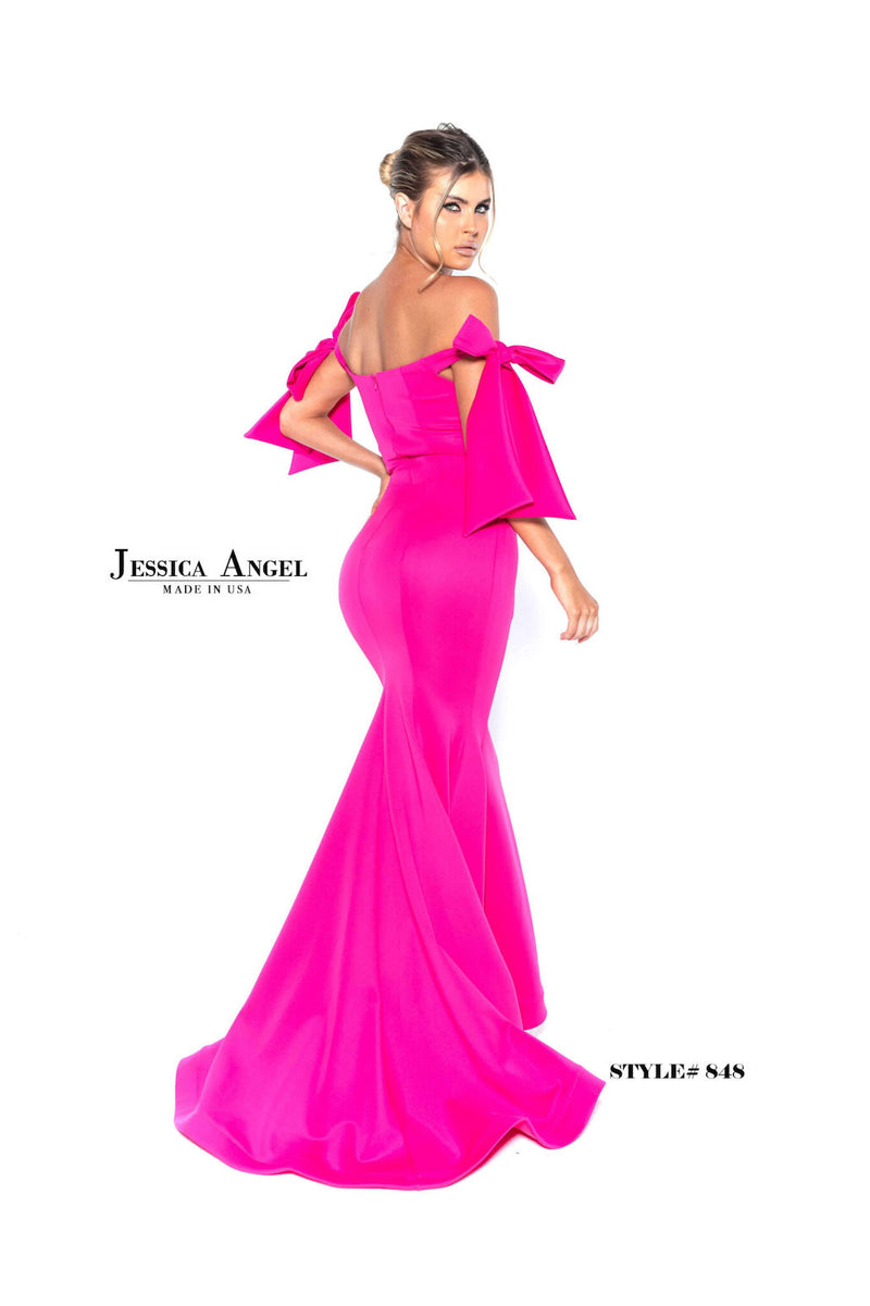 This gown features an off-the-shoulder neckline with bow detailing on both shoulders. The silhouette is fitted with scuba fabric and a slight train. This dress is playful and feminine and ideal for your next prom or formal event.  Jessica Angel 848
