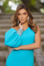 This dress features an asymmetrical neckline with a one-shoulder and an off-the-shoulder long puff sleeve with a crystal-embellished cuff. This dress has a fitted silhouette with a slit and a slight train. It is architectural and unique and could be a great choice for your next prom, pageant or formal event.   ARY 38352