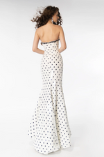 The dress features a strapless neckline with beaded applique on the top seam. The fabric is sequin-embellished with a polka dot print, a fitted silhouette with a slit in the skirt. This dress is fun and unique and could be perfect for your next prom or formal event.  ARY 39253