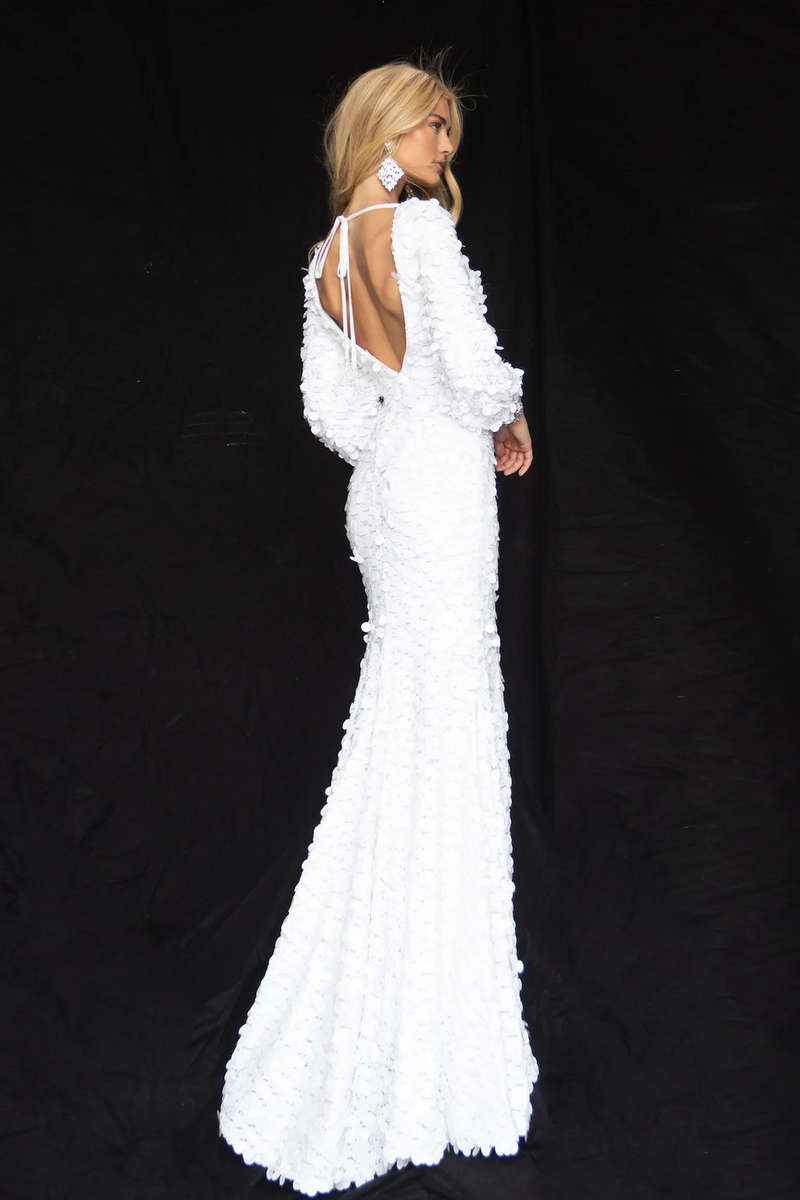 This dress features a fitted silhouette with large-format sequins. The high neckline pairs beautifully with the open back and long sleeves with bejeweled cuffs. The skirt slit and train make this dress a show-stopper, perfect for your next pageant or formal event!  ARY 39256