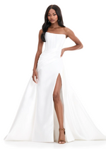 This mikado fabric ballgown features a strapless bodice with intricate pleating and a dramatic overskirt with a front slit. This dress is simple but elegant and could be ideal for your next prom or pageant.

Ashley Lauren 12056