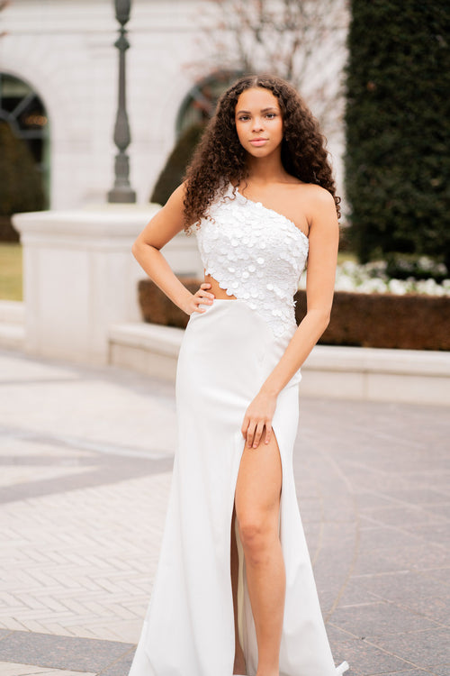 This gown features a one-shoulder neckline with a bodice embellished with large sequins. The silhouette is fitted with a slit in the skirt and a side cut-out on the waistline. This dress is unique and playful and could be perfect for your next prom or formal event.  ARY 39247