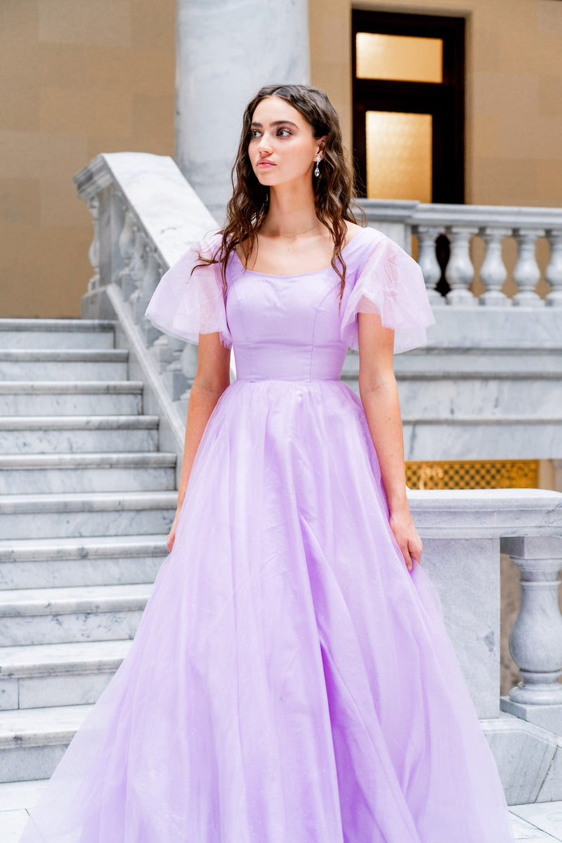 This dress features a square neckline with tulle short sleeves and a back that mirrors the front. This dress has an A-line silhouette and is a great choice for your prom if you are looking for a dress with a bit more coverage.  JAD J24008SP