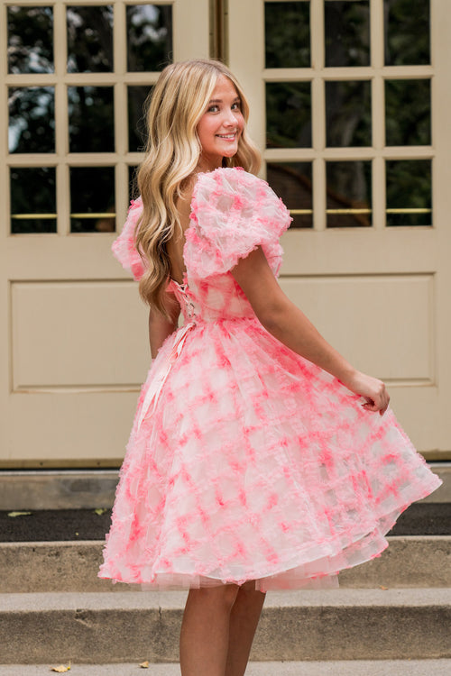 Crafted from cross-hatch tulle in dreamy watercolor pinks, this dress is a true showstopper. The structured corset top offers a universally flattering fit, the voluminous skirt is both playful and feminine, and puff sleeves complete the perfect look for your next homecoming or formal event!

AG 11001