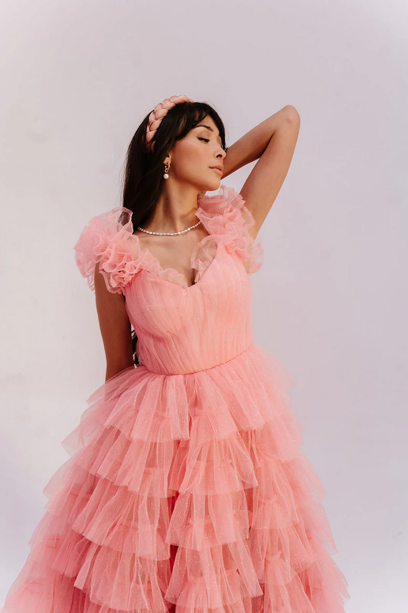 This tea-length dress features sparkling soft tulle fabric, a close-fitting corset, a long gathered skirt that’s layered, and short ruffled sleeves. This dress is playful and could be styling to make it your own at your next homecoming, prom or formal event.

AG 11010