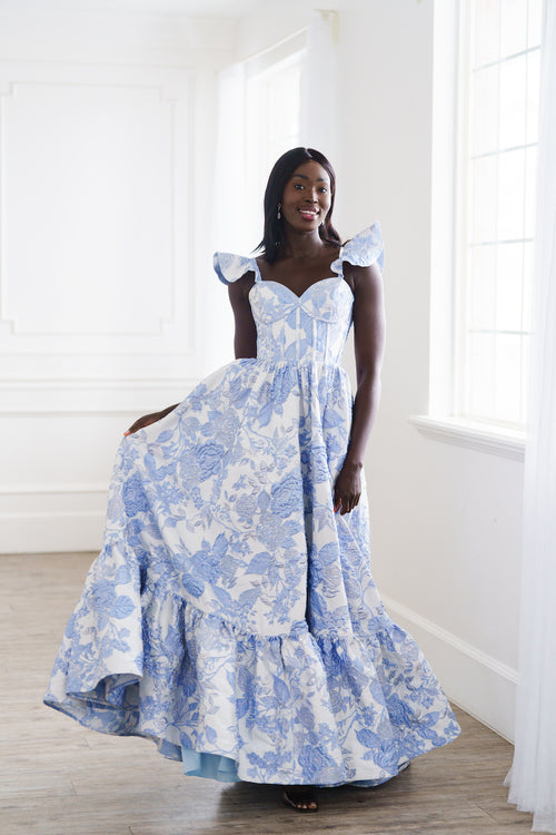 This dress features a sweetheart neckline with spaghetti straps with a ruffle detail, a corset style bodice and brocade fabric. This is a romantic choice for your next prom or formal event.

AG 11002