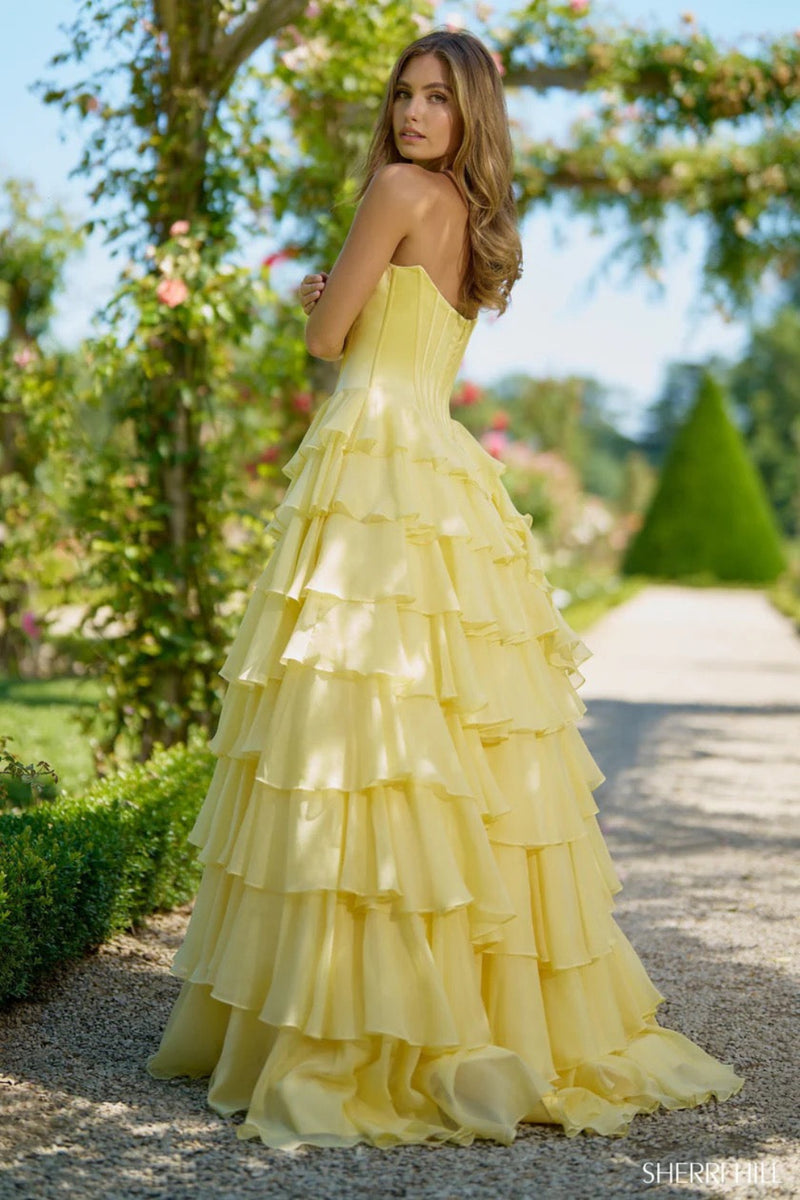 This Sherri Hill gown features a ball gown silhouette, strapless satin corset bodice, and chiffon ruffled skirt and a slit. Pair this dress with dainty heels for the perfect prom look.&nbsp;

Sherri Hill 56911