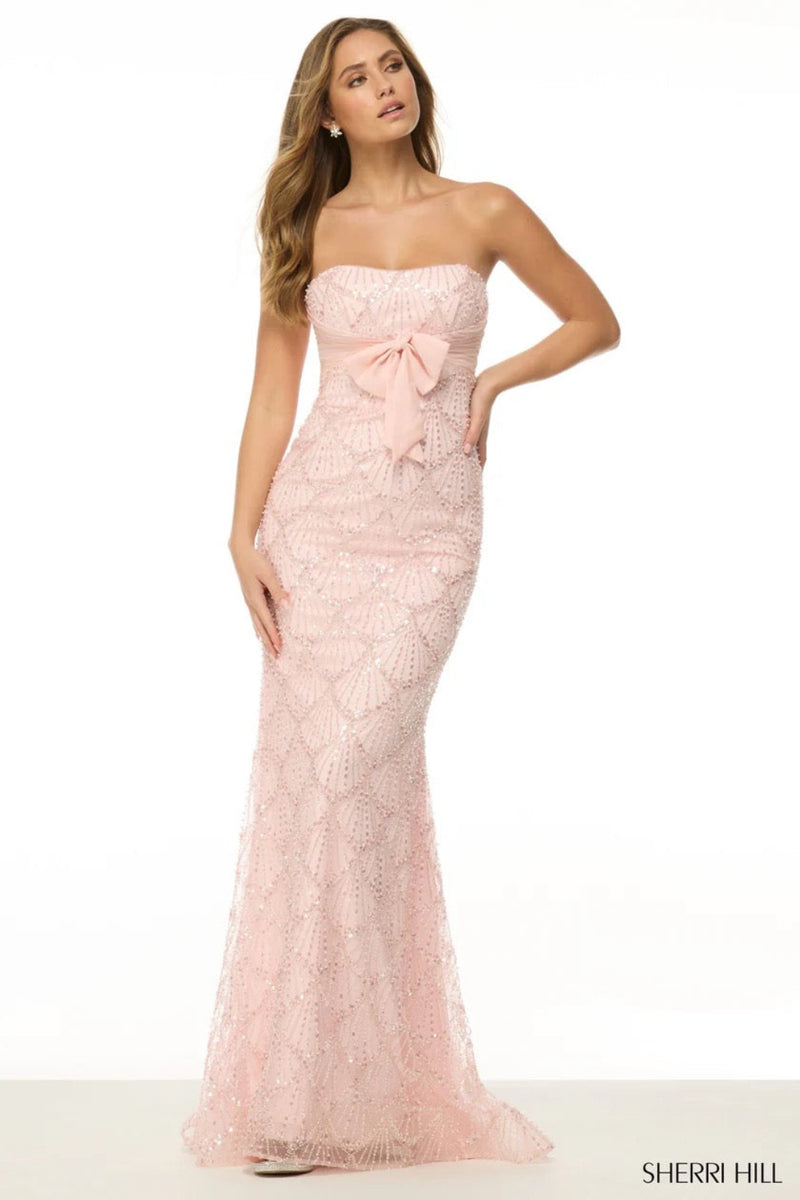Strapless fitted gown with pearl embellishments and chiffon bow.