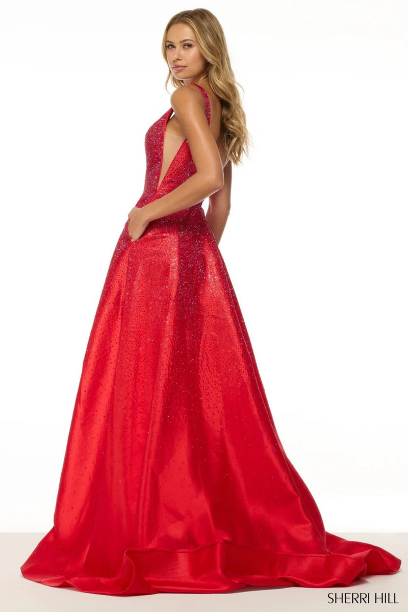 This Sherri Hill gown features an A-line silhouette, hot pressed stones, with sheer sides and slit in the skirt. Pair this dress with some daring earrings for you next prom or formal event.&nbsp;

Sherri Hill 56990
