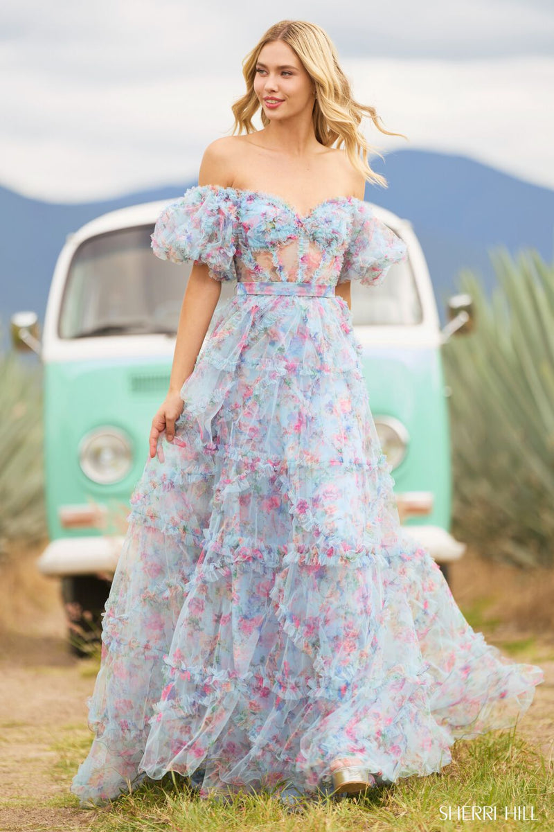 <p><span>This gown features tulle floral print fabric with a sheer corset bodice with ruffle embellishments and balloon sleeves. The neckline is off-the-shoulder, with a belt tie along the waistline and the skirt has ruffle detailing throughout. This dress has a romantic, boho-vibe which may be perfect for your next prom or formal event.</span></p> <p>Sherri Hill 55541</p>