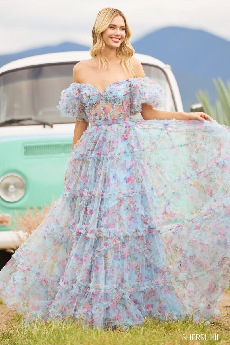 <p><span>This gown features tulle floral print fabric with a sheer corset bodice with ruffle embellishments and balloon sleeves. The neckline is off-the-shoulder, with a belt tie along the waistline and the skirt has ruffle detailing throughout. This dress has a romantic, boho-vibe which may be perfect for your next prom or formal event.</span></p> <p>Sherri Hill 55541</p>