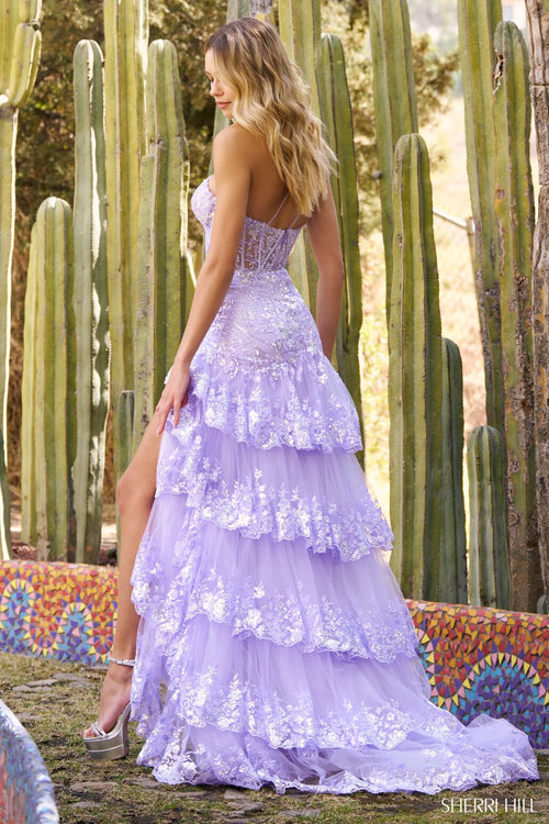 This Sherri Hill gown feautures a one shoulder neckline with corset boning. This dress has sequin fabric and ruffled skirt with a mermaid silhouette with ruffle skirt slit. It is everything unique for your next prom or formal event. Sherri Hill 55800