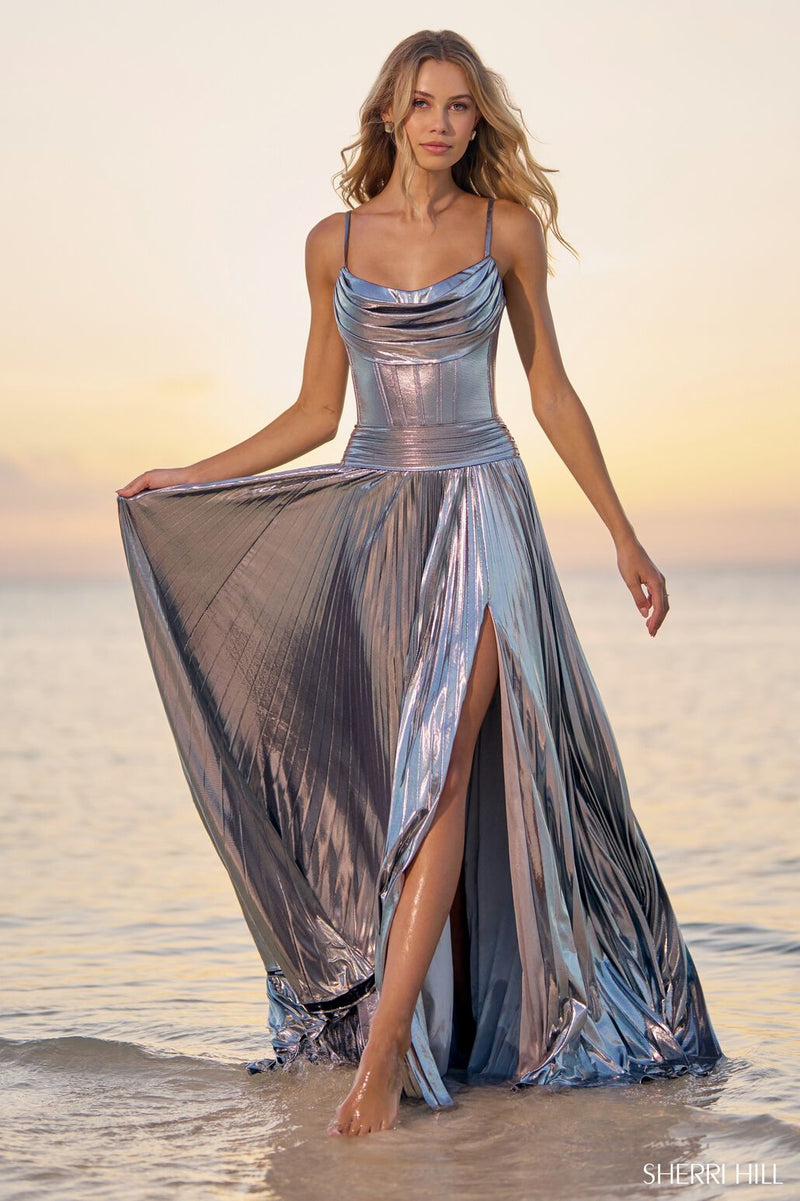 This Sherri Hill gown features metallic pleated fabric with a corset bodice, drape neckline and skirt slit. It is unique and effortless, perfect for your next prom or formal event!  Sherri Hill 56020