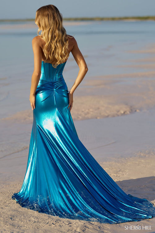 This Sherri Hill gown features a strapless neckline with a fitted silhouette and metallic shine fabric. The high skirt slit, corset bodice, and train are the details that make this dress truly stand out. Could this be the dress for your next prom or formal event? Sherri Hill 56085