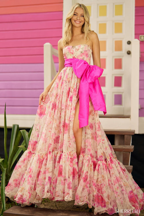 This gown features a strapless neckline with organza floral print fabric with a dramatic taffeta bow and skirt slit. This dress feminine and fun and could be ideal for your next prom or formal event.   Sherri Hill 56110