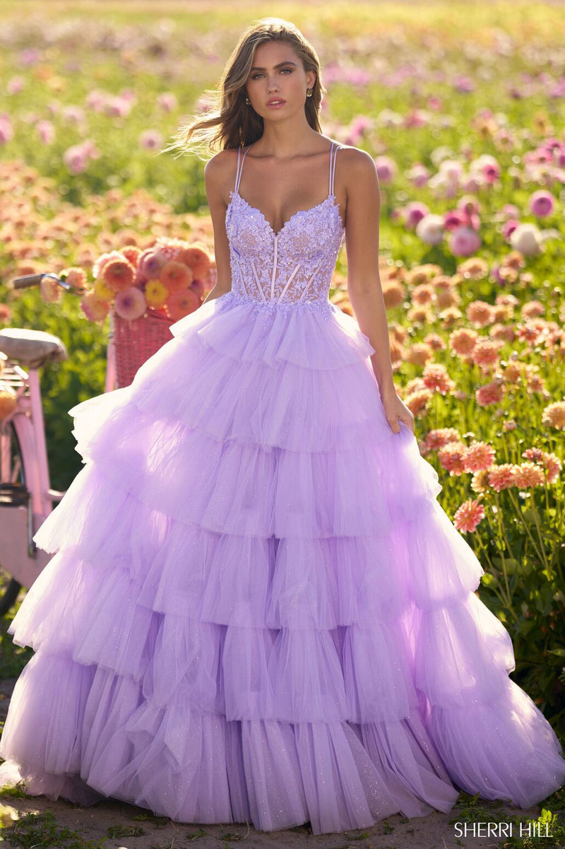This Sherri Hill ballgown features ruffle tulle fabric with a lace corset bodice and lace-up back. The volume on this dress creates a flattering fit and flare that could be ideal for your next prom or formal event.  Sherri Hill 56192