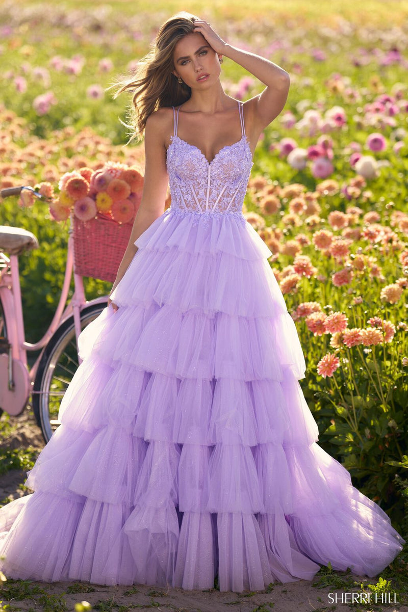 This Sherri Hill ballgown features ruffle tulle fabric with a lace corset bodice and lace-up back. The volume on this dress creates a flattering fit and flare that could be ideal for your next prom or formal event.  Sherri Hill 56192