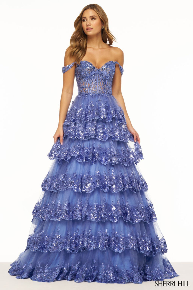 This Sherri Hill ballgown features a ruffle tulle lace sequin fabric with a sheer corset bodice, sweetheart neckline, off-the-shoulder straps and lace up back. This dress is not your average prom dress, it is sure to make a statement at your next prom or formal event.   Sherri Hill 56196