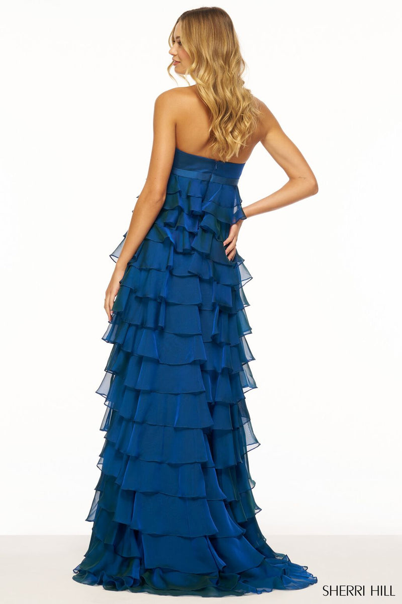 This dress features a strapless neckline with a ruffle tiered skirt and bow embellishment along the empire waist belt. This dress is unique and feminine and could be ideal for your next prom or formal event.  Sherri Hill 56226