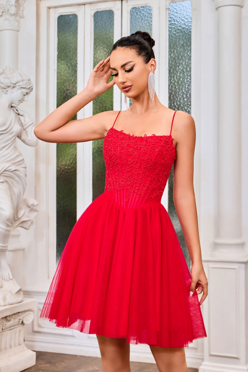 This cocktail dress features a straight across neckline, spaghetti straps, with a lace-up back. The bodice has corset boning with lace applique and the tulle skirt creates an A-line silhouette. This dress may be just the vibe for your next homecoming or formal event.  JAD J24079