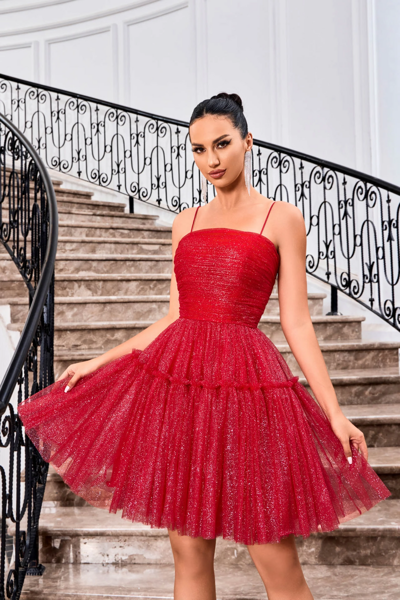 This cocktail dress features a straight across neckline with spaghetti straps and a lace-up back. The glitter tulle fabric creates an A-line silhouette and a playful vibe. Style this dress to make it your own at your next homecoming, sweethearts or formal event.  JAD J24090