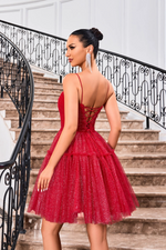 This cocktail dress features a straight across neckline with spaghetti straps and a lace-up back. The glitter tulle fabric creates an A-line silhouette and a playful vibe. Style this dress to make it your own at your next homecoming, sweethearts or formal event.  JAD J24090