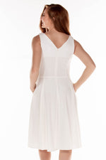 This ERE 3915 flowy cocktail dress in white features a V-neckline on the bodice and pockets. 