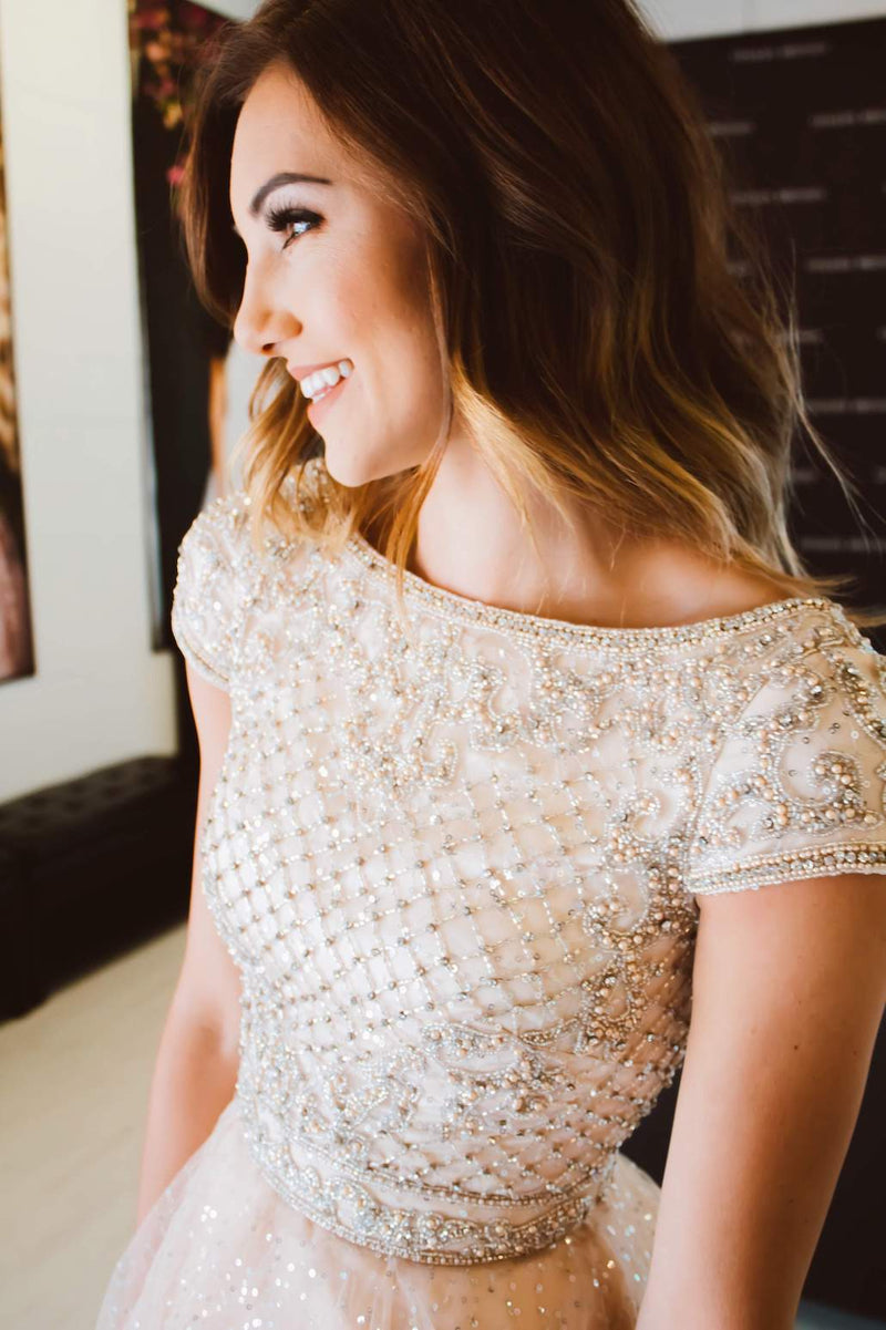 This Sherri Hill 52273 cocktail dress in nude/silver features a beaded bodice and a sequin tulle skirt. 