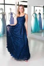 This. DJ A9361 simple lace gown in navy features a straight neckline and an open back. 
