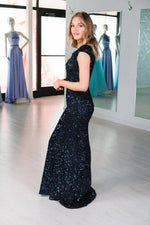 This MJS 20-502M fitted gown in navy features cap sleeves, a high back, and sequin beading throughout. 
