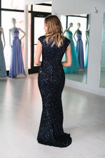 This MJS 20-502M fitted gown in navy features cap sleeves, a high back, and sequin beading throughout. 