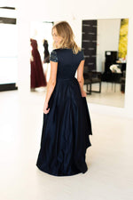 This Mac Duggal 25947 A-line gown in navy features a modest cap sleeve with a high neckline and back. 