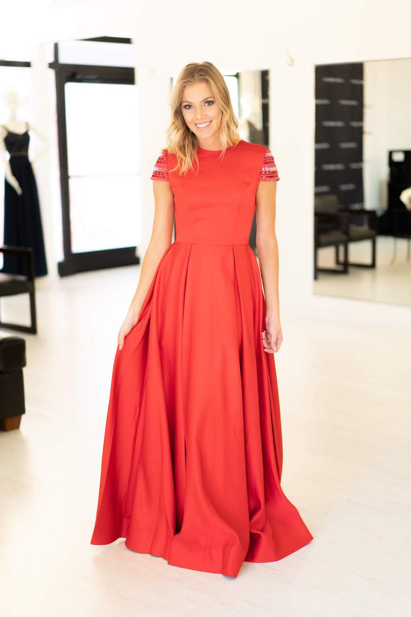 This Mac Duggal 25947 A-line gown in red features a modest cap sleeve with a high neckline and back. 