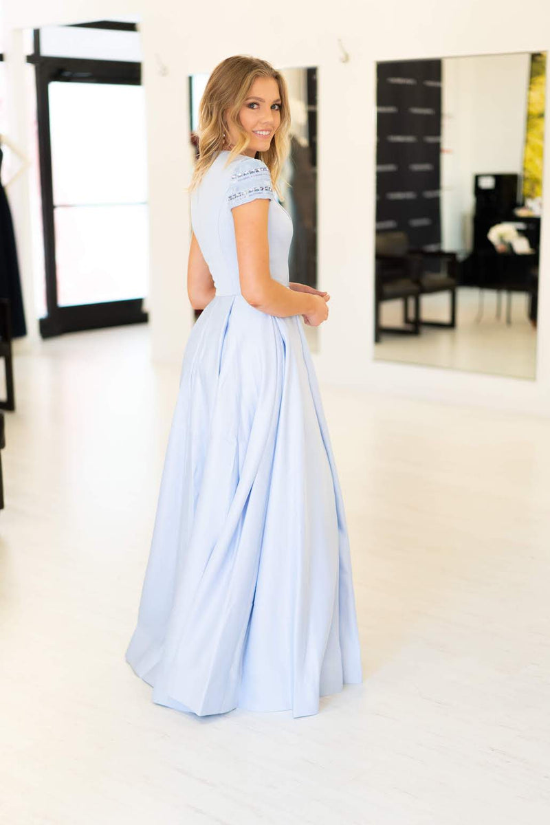 This Mac Duggal 25947 A-line gown in light blue features a modest cap sleeve with a high neckline and back. 