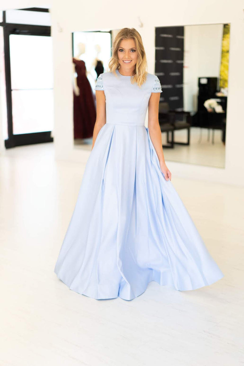 This Mac Duggal 25947 A-line gown in light blue features a modest cap sleeve with a high neckline and back. 