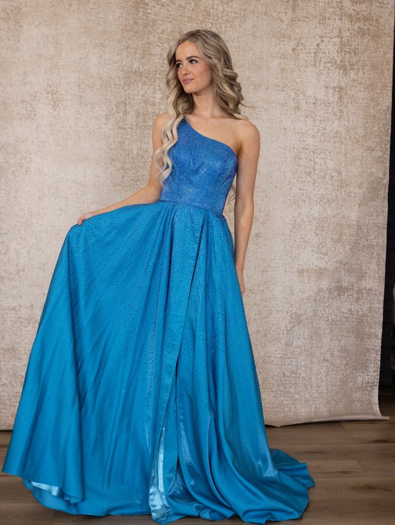 Kemly features a one-shoulder design with thick waistband and high slit. This fun iridescent fabric would make for the perfect prom dress.   PY 8920