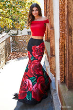 This Sherri Hill 51850 two-piece gown in red/black print features an off-the-shoulder bodice with a keyhole back and a floral mermaid skirt.